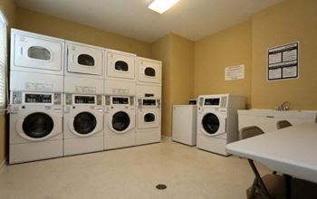 A laundromat with rows of washers and dryers. at Robinson Park Apartments, Harrisonburg 22801